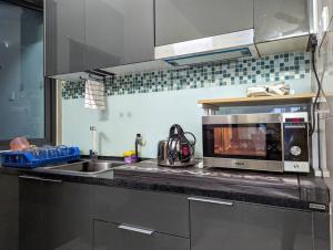 普特拉贾亚AZ Homestay的厨房配有水槽和微波炉