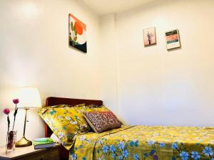 Iloilo Affordable Transient - near Iloilo Airport的一间卧室配有一张床和一张带台灯的桌子