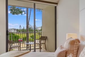 金斯克里福Deluxe Dual-Key Apartment in Peppers @ Salt Resort by uHoliday (3BR, 2BR and Hotel Room Options Available)的一间卧室设有一张床,享有阳台的景色
