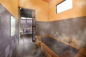 南小国町山忍酒店的一间带大浴缸及窗户的浴室