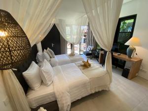 塞米亚克Lotus Luxury Villa Seminyak的一间卧室设有两张床和大窗户