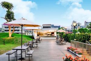 嘉义市新悦花园酒店的一个带桌椅和遮阳伞的庭院