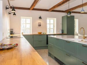 南奥默Holiday home Sønder Omme II的一间铺有木地板的大厨房,配有绿色的橱柜
