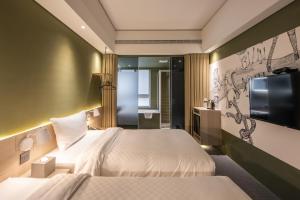台中市城市漫游行旅的酒店客房设有两张床和一台平面电视。