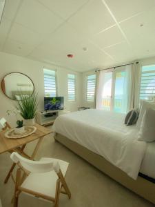 林康Tres Palmas by La Cambija的卧室配有一张白色大床和镜子