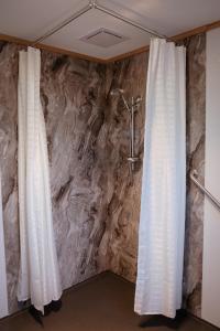 Mount RumneyMount Rumney Escapes Seaview House 2 - Eagle House的浴室设有两扇白色窗帘和石墙