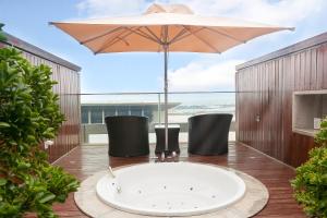 青岛青岛海尔洲际酒店（奥林匹克帆船中心内）的甲板上的浴缸配有遮阳伞