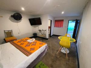 马普托Aeropark Residencial (B&B)的一间卧室配有一张床和一张黄色椅子