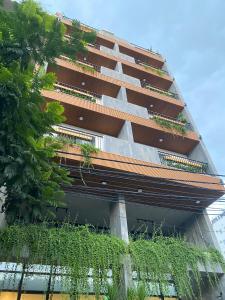 岘港LAGOM APARTMENT AND HOTEL的一座植物在建筑的一侧