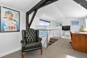 莱伊Highbury Coastal Villa的一间带椅子、书桌和电视的房间