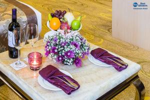 仰光Best Western Chinatown Hotel的一张桌子,上面放着水果、鲜花和酒杯