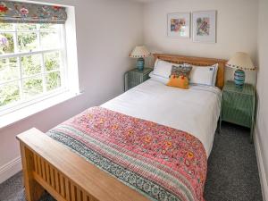 West AshbyThe Green House的一间卧室配有带2个床头柜和2个窗户的床