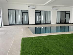 Al QābilBedyiah Green Homes的绿色地毯建筑中的游泳池