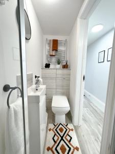 KentThe Bohemian Basement的浴室配有白色卫生间和盥洗盆。