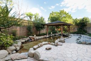 京都ManyonoyuHotelKyotoEminence的一个带池塘和凉亭的花园
