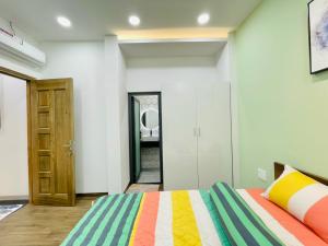胡志明市Thái Vân Home的一间卧室配有一张带彩色毯子的床