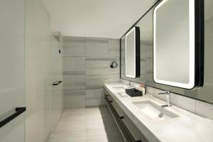 大连大连星海皇冠假日酒店的一间带两个盥洗盆和淋浴的浴室