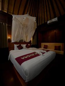 蓝梦岛蓝梦岛达玛拉酒店的一间卧室配有一张带蚊帐的大床