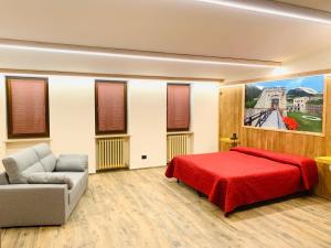 维纳迪奥Hotel Ristorante Ligure的一间卧室配有红色的床和一张沙发