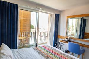 阿卡雄Best Western Arcachon Le Port的一间卧室设有一张床和一个阳台的窗户。