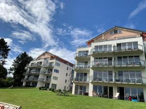 阿舍贝格Ferienwohnung am Großen Plöner See的两栋公寓楼,前面设有草坪