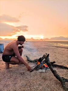 Ao LukKRABI BAMBOO KINGDOM at AOLUEK PARADISE的一个人在海滩上 ⁇ 火做饭