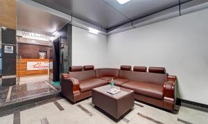 钦奈Treebo Trend Vetri Supreme Residency的一间配备有皮沙发和桌子的等候室