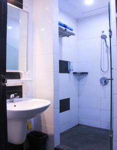 BagansinembahSuzuya Hotel Bagan Batu的白色的浴室设有水槽和淋浴。