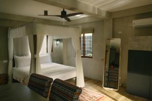 卢纳将军城Domu Mia Villa Siargao的卧室配有一张床和一张桌子及椅子