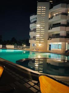 班派克龙菲Rayong Condo Chain studio room的一座游泳池,在晚上在建筑物前