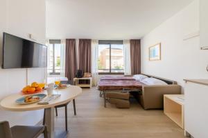 比利亚努埃瓦-赫尔特鲁雅典娜公园套房公寓的酒店客房配有一张床铺和一张桌子。