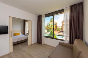 比利亚努埃瓦-赫尔特鲁雅典娜公园套房公寓的酒店客房设有一张床和一个大窗户
