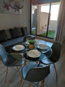 博尔穆霍斯Apartamento Servet, parking gratuito, a 5 minutos de Sevilla的一间设有玻璃桌和椅子的用餐室