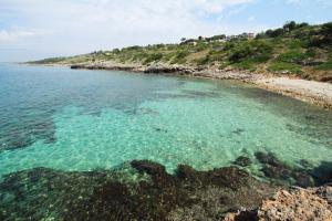 莱乌卡Le Dimore Sul Mare di San Gregorio的一片清澈的海水和岩石海岸的海滩