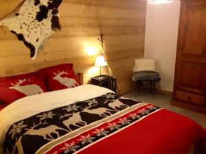 MégevetteChalet Eterlou的一间卧室配有一张带红色枕头的床和一面墙