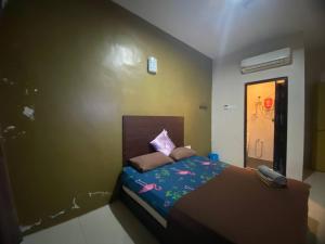 关丹TGL Aparthotel Tanjung Lumpur的一间卧室配有一张床,上面有电话