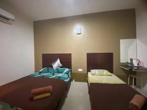 关丹TGL Aparthotel Tanjung Lumpur的客房设有两张床和水槽。