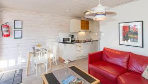 格里姆斯塔Topcamp Bie - Grimstad的一间带红色沙发的客厅和一间厨房