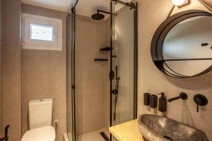 卡尼奥提Calypso beach front apartment的一间带水槽、镜子和卫生间的浴室