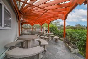 新奥尔良市PLUS诺斯伍兹贝斯特韦斯特酒店的橙色凉亭下带桌椅的天井