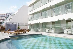 波多黎各麦格纳别墅酒店的一座带椅子的游泳池以及一座建筑