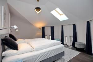 海利根达姆Villa Greif Wohnung 05的卧室配有一张带黑色枕头的大型白色床。