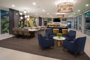 GaltLa Quinta Inn & Suites by Wyndham Galt Lodi North的大堂设有蓝色的桌椅和餐厅。