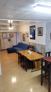 Arazato宮古島ゲストハウス　マウイ的客厅配有桌子和蓝色沙发