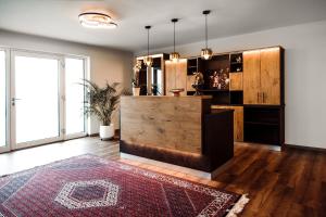 OberhaagKOASA HOF Bed and Breakfast的客厅配有木柜台和地毯。