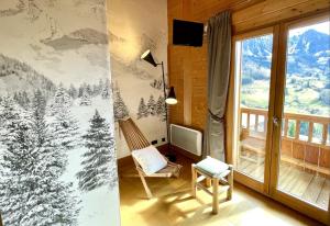 马尼戈Chalet Alpaga Location de prestige的一间设有椅子和拥有雪覆盖树木的窗户的房间