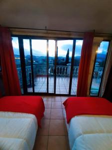 图伊Albergue Villa San Clemente的客房设有两张床和大窗户。