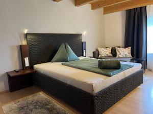 林茨布拉克尼加特酒店的一间卧室配有一张大床和一张沙发