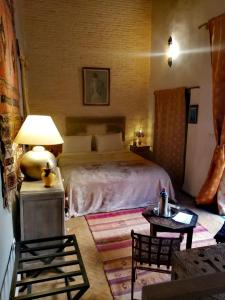 非斯Les Bains de Fez Tara的卧室配有一张床和一张桌子及椅子