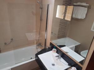 马拉加卡斯蒂亚格雷罗酒店的一间带水槽、浴缸和镜子的浴室
